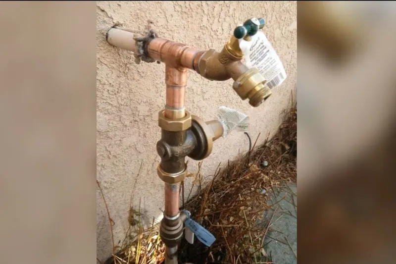 Outdoor faucet and exposed pipe connection being repaired for Disconnecting a hose